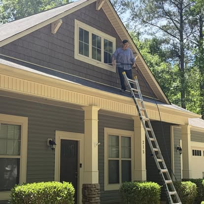 Crew on roof of craftsman home performing full-service gutter cleanout